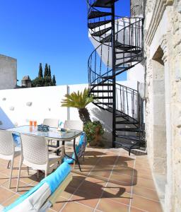 a patio with a table and chairs and a spiral staircase at Villa Radamanthis in Sívas