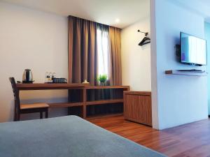 Habitación de hotel con escritorio y TV en The Leverage Lite Hotel - Kuala Kedah en Alor Setar