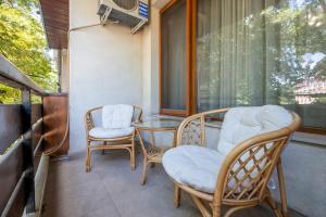 2 stoelen en een glazen tafel op een balkon bij Spacious Newly Furnished 1 BDRM Apartment in Sofia
