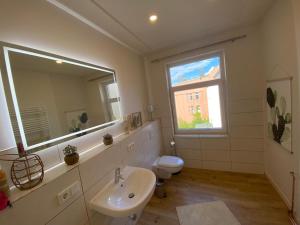 ein Badezimmer mit einem Waschbecken, einem WC und einem Spiegel in der Unterkunft Ferienwohnung PIER 2 in Cuxhaven in Cuxhaven
