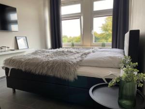 a bedroom with a bed with a table and a window at Ferienwohnung PIER 2 in Cuxhaven in Cuxhaven