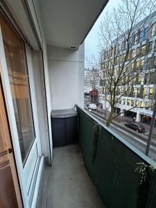 Elle comprend un balcon offrant une vue sur une rue de la ville. dans l'établissement Appart. familial aux portes de Paris, à Montrouge