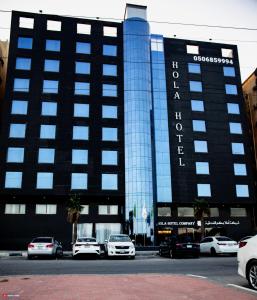 un edificio con coches estacionados frente a él en Hola Hotel en Al Jubail