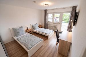 a bedroom with two beds and a desk and a window at Bookandstay24 Münster bei Darmstadt, Frankfurt, Rhein Main Gebiet in Münster