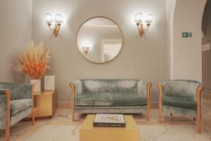 a living room with two chairs and a mirror at Hotel City Palazzo Dei Cardinali in Rome