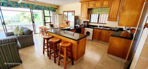 a kitchen with wooden cabinets and a island with bar stools at Seanique - sleeps 8 in Margate