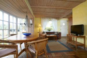 a living room with a table and a television at Meeressterne Strandhäuser Blankenfohrt in Ueckeritz