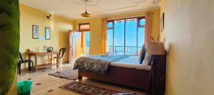 a bedroom with a bed with a view of the ocean at The Unmad - Dharamkot in Dharamshala