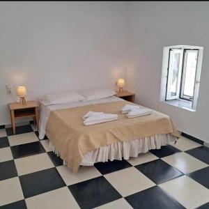 - une chambre avec un lit avec deux lampes et un sol en damier dans l'établissement Nikol's house, à Kámpos