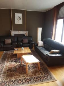 a living room with a black leather couch and a coffee table at Lovely Bourg house 4 pers 2 bedr 2 bath Wifi in Charleroi