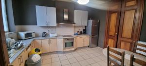 a kitchen with white cabinets and a stove top oven at Lovely Bourg house 4 pers 2 bedr 2 bath Wifi in Charleroi