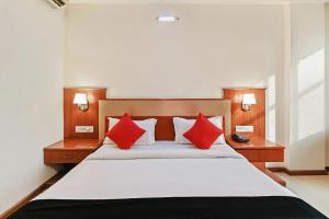 Hotel Royal Empire في جايبور: غرفة نوم بسرير كبير ومخدات حمراء