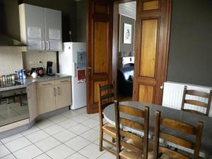 a kitchen with a table and a kitchen with a refrigerator at Lovely Bourg house 4 pers 2 bedr 2 bath Wifi in Charleroi