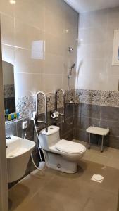 ein Bad mit einem WC und einem Waschbecken in der Unterkunft GOLDEN NEW UMU ALQURAA Hotel in Dschidda