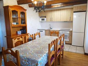 uma cozinha com uma mesa e cadeiras e um frigorífico branco em Casa Rural ERTEIKOA - Selva de Irati em Aria