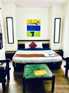 a bedroom with a bed with a table in it at HOTEL SUNSHINE in Nagpur