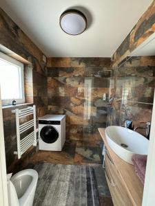 a bathroom with a toilet and a sink and a tub at Chalet Weiß in Mönichkirchen