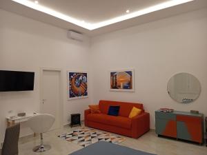 - un salon avec un canapé rouge et une télévision dans l'établissement Megaride Domus, à Ercolano