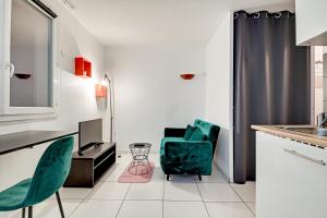 a kitchen with two green chairs and a sink at Budget Studio with parking in Cergy