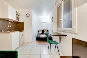 a kitchen with a table and a couch in a room at Budget Studio with parking in Cergy