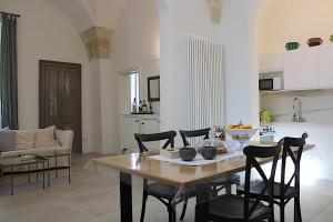 cocina y sala de estar con mesa y sillas en Li Frati Suite en Lecce