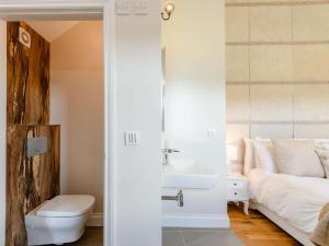 ein Badezimmer mit Waschbecken und Toilette und ein Bett in der Unterkunft Romantic cottage for 2 with hot tub in Wimborne Minster + 7 Fotos