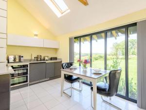 uma cozinha com mesa e cadeiras e uma janela em Romantic cottage for 2 with hot tub em Wimborne Minster