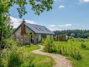 ein Haus mit einem Schotterweg davor in der Unterkunft Romantic cottage for 2 with hot tub in Wimborne Minster
