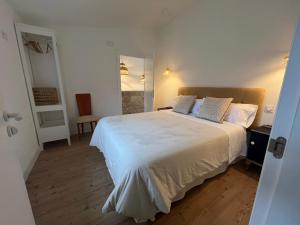 ein Schlafzimmer mit einem großen weißen Bett mit zwei Kissen in der Unterkunft El Pecu Casa Rural in Bustillo del Páramo