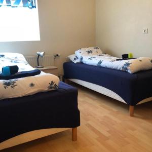 1 dormitorio con 2 camas con sábanas azules y blancas en Vestmannsvatn Guesthouse en Aðaldalur