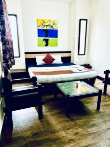 a bedroom with a bed and a table and a chair at HOTEL SUNSHINE in Nagpur