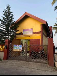 um pequeno edifício com um portão em frente em Koa's Beach House em Tangalan