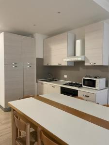 eine Küche mit weißen Schränken und einer Arbeitsplatte in der Unterkunft RESIDENCE PANFILO - WALTERIGATO Apartments SOLO PER FAMIGLIE in Lido di Jesolo