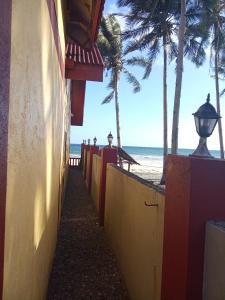 a sidewalk next to a beach with palm trees at Koa's Beach House in Tangalan