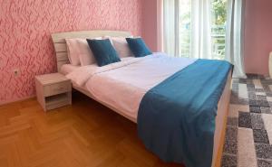 a bedroom with a bed with blue and pink walls at Charming Modern Condo near City Center Free Parking & Fully Equipped in Skopje