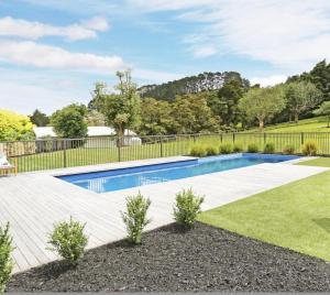 una piscina in un cortile con recinzione di Ranfurly holiday home ad Auckland