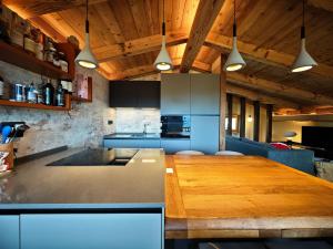 a kitchen with a wooden table in a room at Hostdomus - Chalet Sun in Sestriere