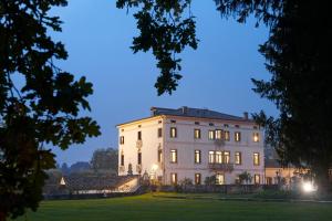 una grande casa bianca di notte con luci accese di Villa Stecchini a Bassano del Grappa