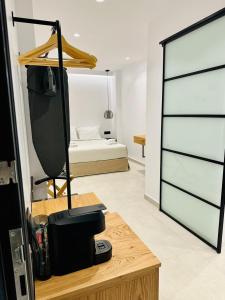 een kamer met een slaapkamer met een bed en een bureau bij Bonita Luxury Room in Mykonos-stad