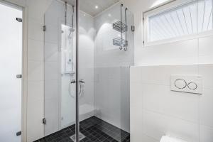 a white bathroom with a glass shower stall at Cozy & luxurious relaxation - Suopursu Lux in Rovaniemi +22 photos
