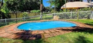a small swimming pool in a yard with a fence at Kwabiela 3 - Sleeps 6 in Margate