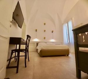 a bedroom with a bed and a desk and a chair at Li Frati Suite in Lecce
