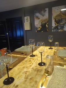 um grupo de copos de vinho sentados numa mesa de madeira em Chez Ana à Morez em Morbier