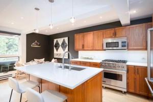 a kitchen with a white counter top and wooden cabinets at Aspen Core Renovated 2 BR, 2 BA with AC in Aspen