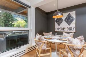 a dining room with a table and chairs and a window at Aspen Core Renovated 2 BR, 2 BA with AC in Aspen