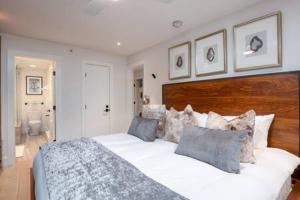 a bedroom with a large white bed with a wooden headboard at Aspen Core Renovated 2 BR, 2 BA with AC in Aspen +39 photos