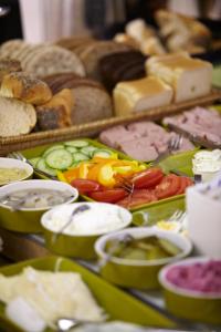 a table filled with different types of bread and vegetables at Riverside Apartments in Ängelholm