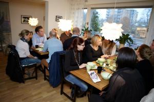 un grupo de personas sentadas en mesas en un restaurante en Riverside Apartments, en Ängelholm
