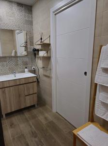 een badkamer met een witte deur en een wastafel bij El Tesoro de la Mezquita in Córdoba