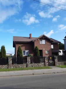 a brown brick house with a stone fence at U Lubockich in Rewa